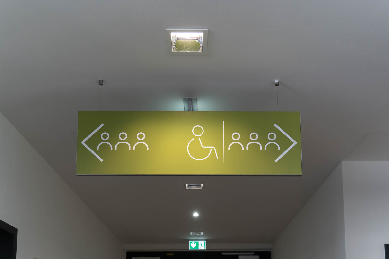 grüne Hinweistafel mit Zeichen Rollstuhlfahrer