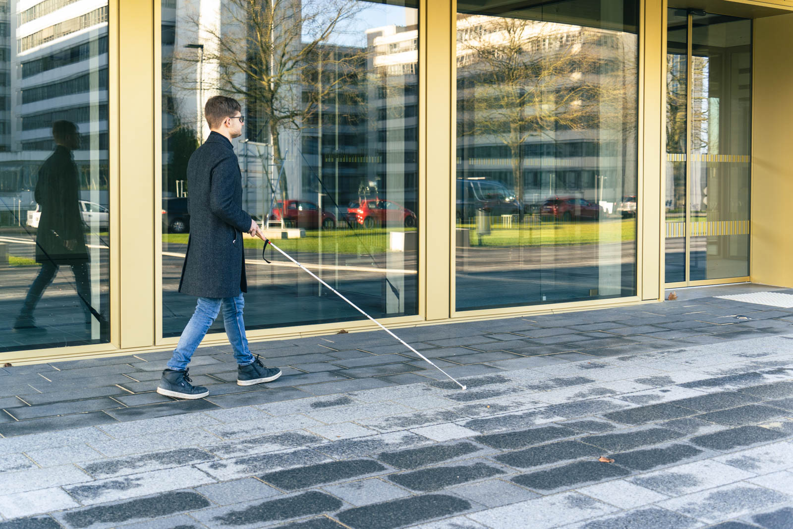Blinder Studierender vor dem Hörsaal-Gebäude der Universität Bielefeld