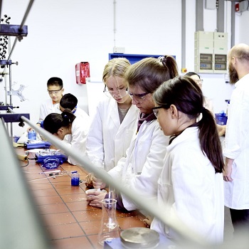 Children experiment in white coats in the laboratory