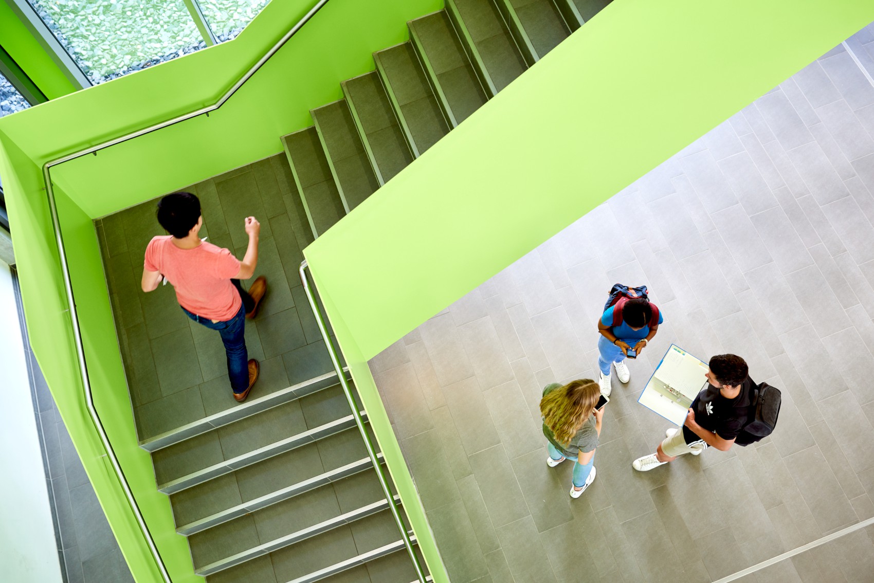 Studierende laufen eine grne Treppe hoch