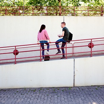Zwei junge Menschen sitzen auf Geländer