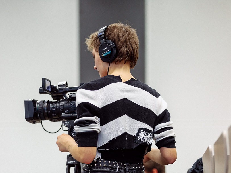 Rückenansicht einer Person, die eine Filmkamera bedient